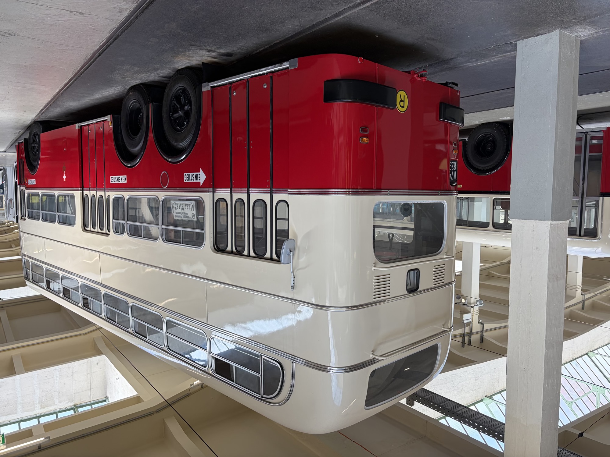 Doppelstockbus mit drei Achsen und drei Eingangsbereichen, im oberen Teil sind mehrere Schiebefenster geöffnet, der Bus trägt ein schwarzes Wiener Nummernschild